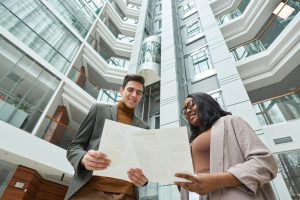 Profissionais analisando documentos em átrio moderno de prédio no interior Mato Grosso.