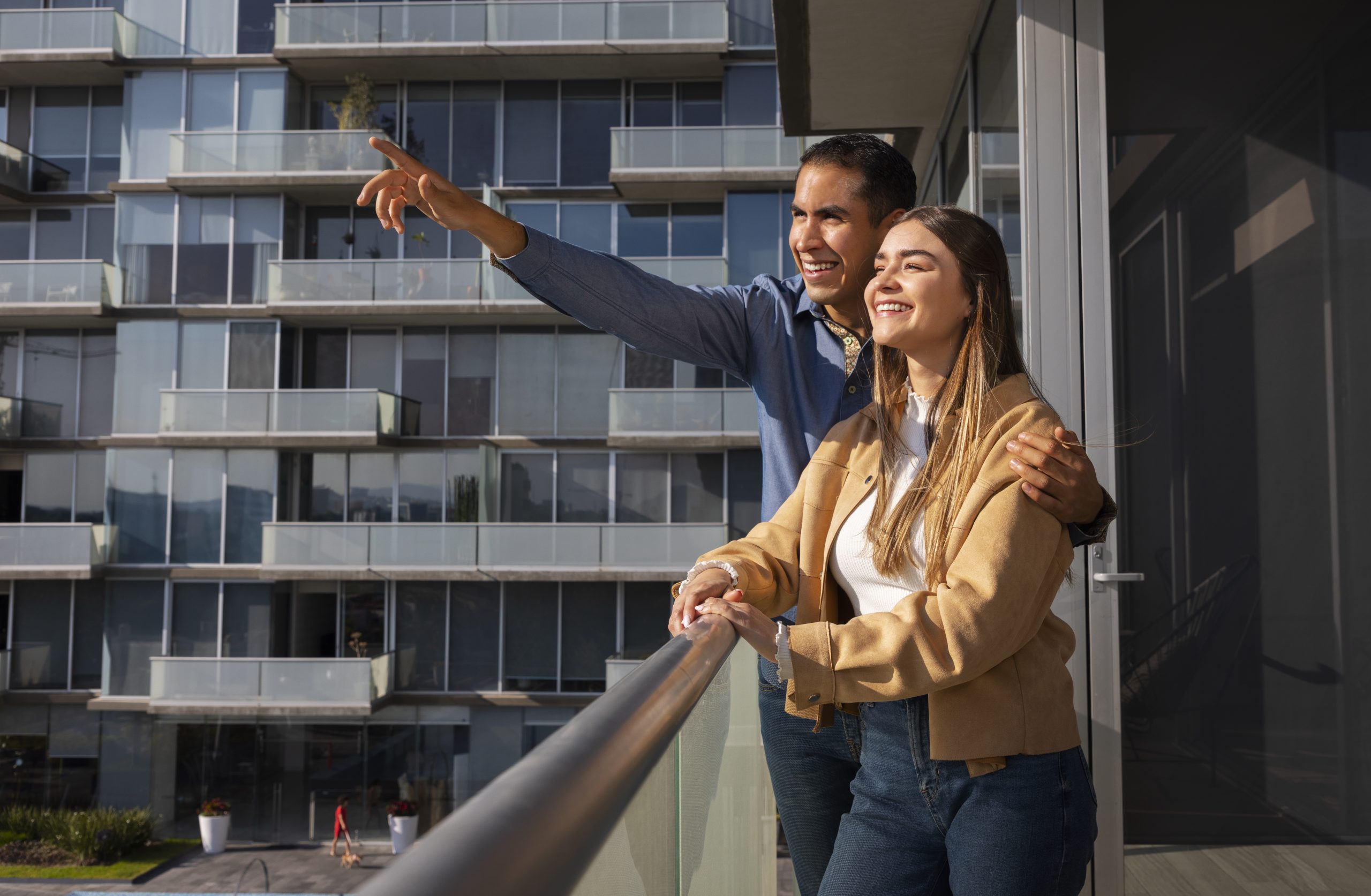 Casal observando a vista da varanda de apartamento de alto padrão.